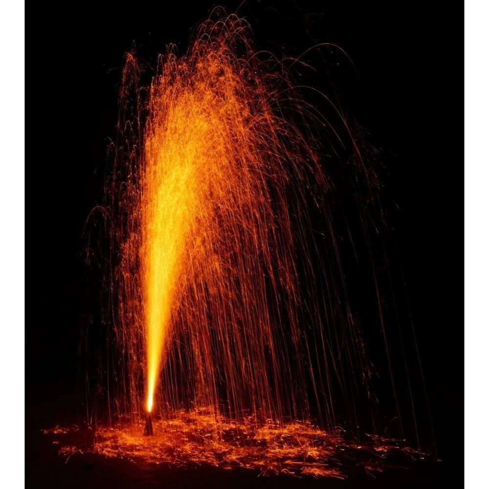 Leuchtende Goldvulkan-Fontäne bei Nacht mit dichtem orangegelben Funkenkegel und herabfallenden Funken